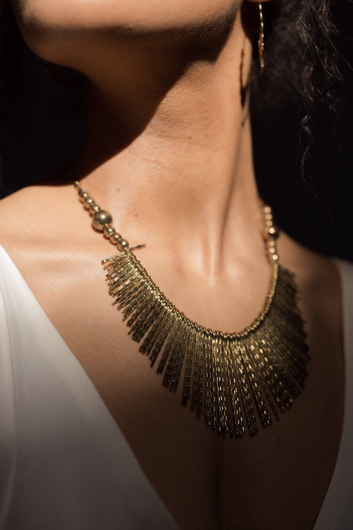 Close-up of a luxurious gold necklace worn by a model, perfect for fashion and jewelry themes.